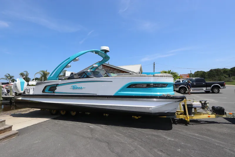 Slide: The Image of 2022 Tahoe Pontoon Grand Tahoe Twin Elite M2785 on trailer, parked outdoors. - 1