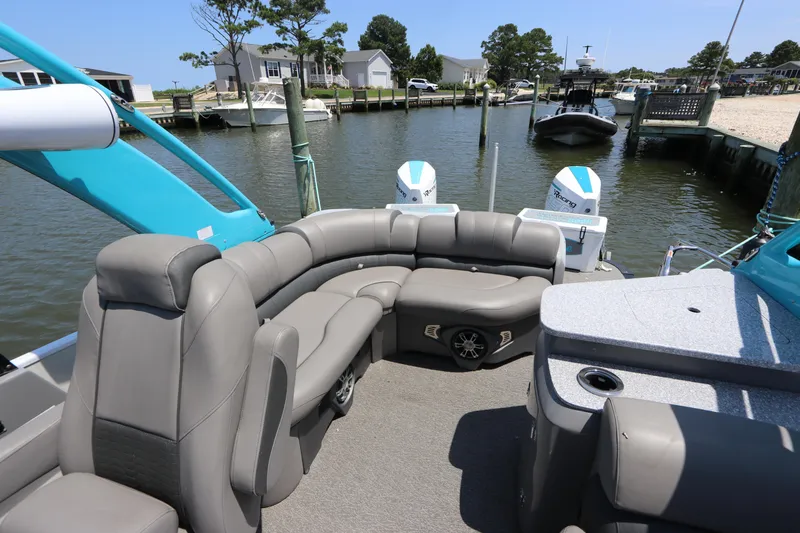Slide: The Image of 2022 Tahoe Pontoon Grand Tahoe Twin Elite M2785 with luxurious seating at a marina. - 11
