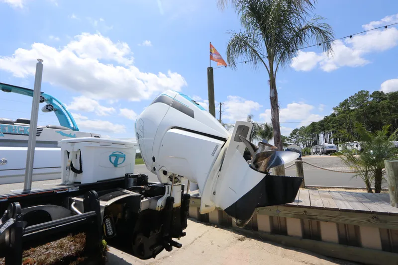 Slide: The Image of 2022 Tahoe Pontoon Grand Tahoe Twin Elite M2785 with outboard motor, parked near palm trees. - 4