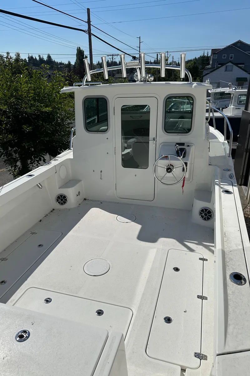 Slide: The Image of 2025 Parker 2420 Sport Cabin boat with spacious deck and modern cabin design. - 11