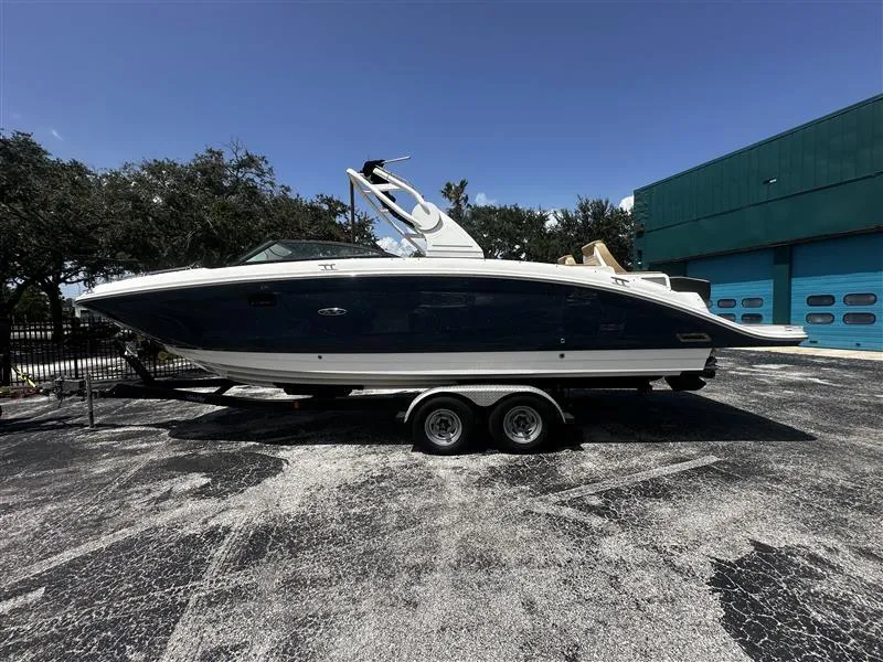 Slide: The Image of 2019 Sea Ray SDX 290 boat on trailer, parked outdoors near a building. - 1