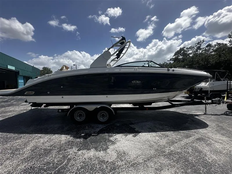 Slide: The Image of 2019 Sea Ray SDX 290 boat on trailer under a partly cloudy sky. - 2