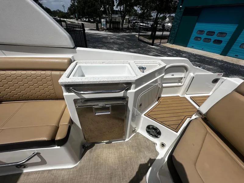 Slide: The Image of 2019 Sea Ray SDX 290 boat interior with seating, sink, and storage. - 9