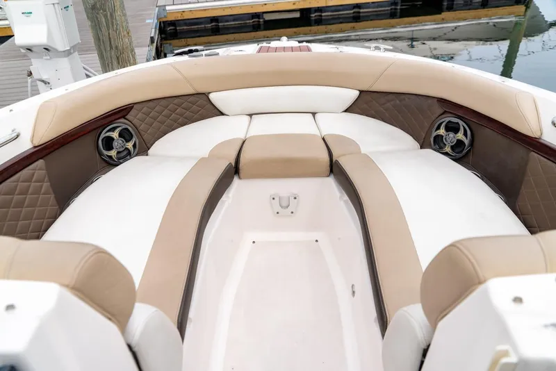 Slide: The Image of 2013 Regal 2700 ES Bowrider boat interior with beige and white cushioned seating. - 15