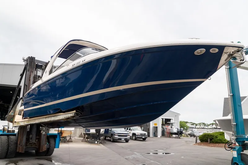 Slide: The Image of 2013 Regal 2700 ES Bowrider boat lifted at a marina. - 3