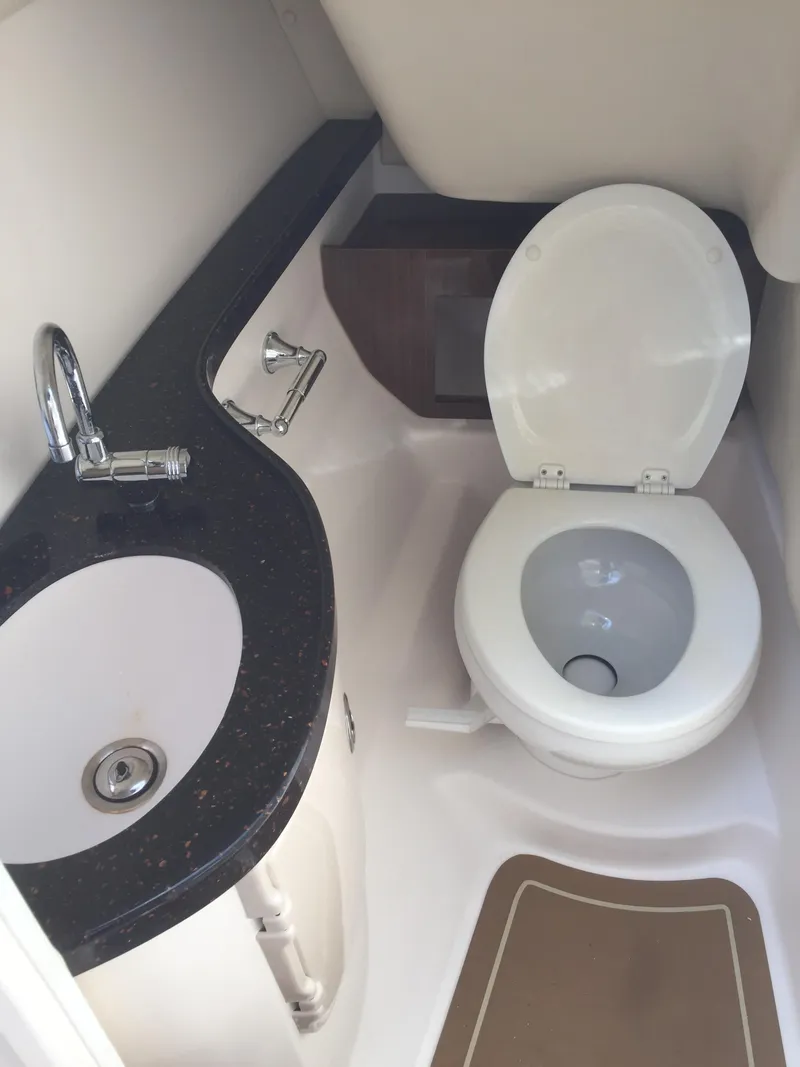 Slide: The Image of 2013 Regal 2700 ES Bowrider boat bathroom with sink and toilet. - 8