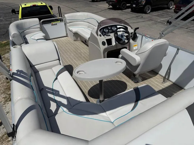 Slide: The Image of 2018 G3 V20C pontoon boat interior with seating, steering console, and table. - 7