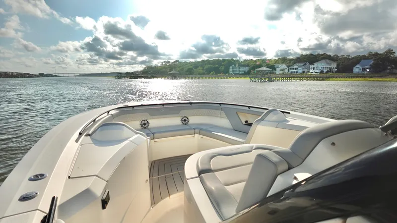 Slide: The Image of 2023 Scout 377 LXF boat on a scenic river with luxury seating and waterfront homes. - 13