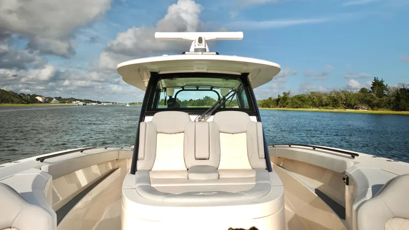 Slide: The Image of 2023 Scout 377 LXF boat on calm water with scenic background. - 15