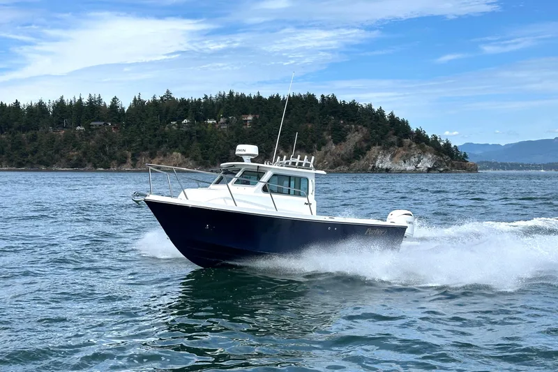 Slide: The Image of 2026 Parker 227 Explorer boat cruising on scenic water with forested island backdrop. - 11