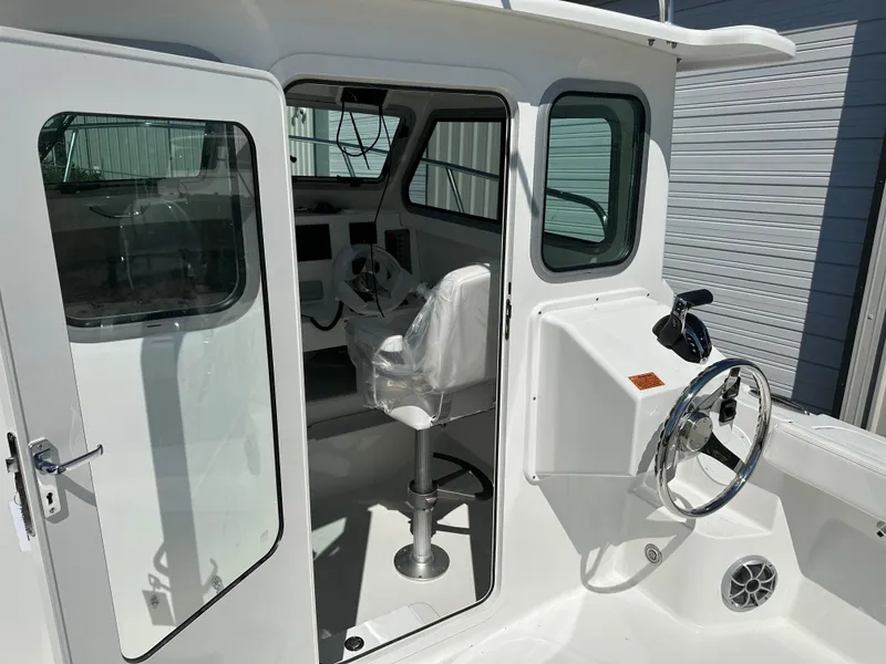 Slide: The Image of 2026 Parker 2220 boat interior with steering wheel and seating, showcasing modern design. - 24