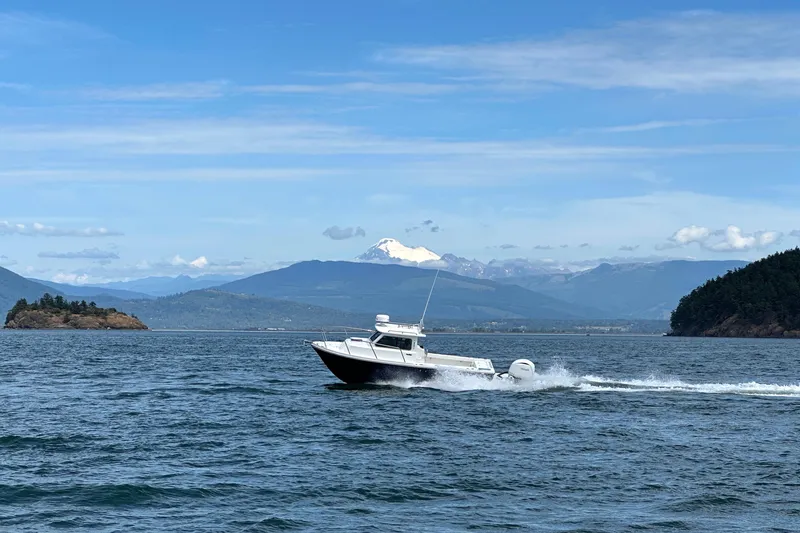 Slide: The Image of 2026 Parker 227 Explorer boat cruising on scenic lake with mountainous backdrop. - 31