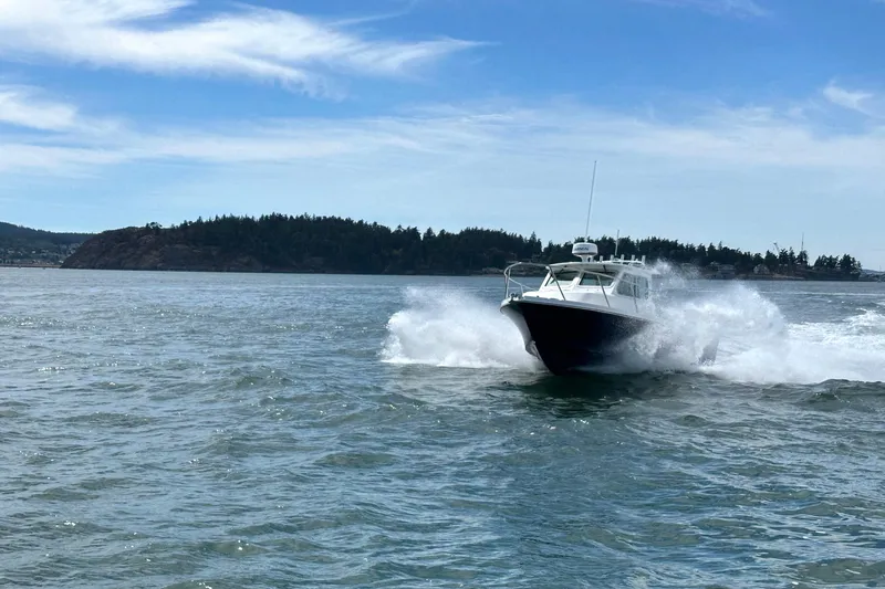 Slide: The Image of 2026 Parker 227 Explorer boat cruising on open water with scenic island backdrop. - 33