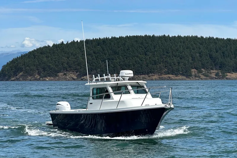 Slide: The Image of 2026 Parker 227 Explorer boat cruising on a scenic lake with forested island backdrop. - 4