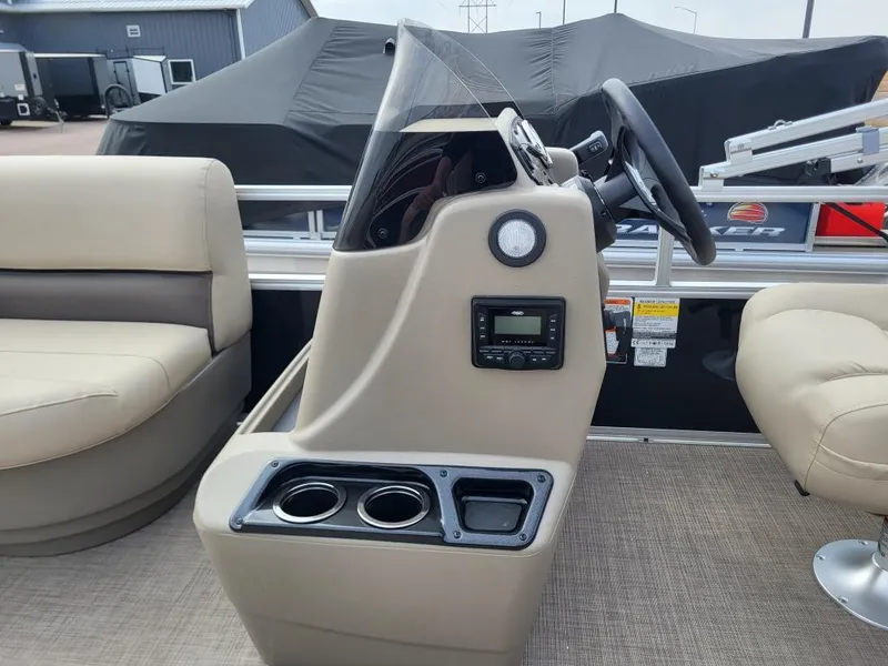 Slide: The Image of 2025 Sun Tracker Party Barge 16 DLX helm with steering wheel and cup holders. - 10