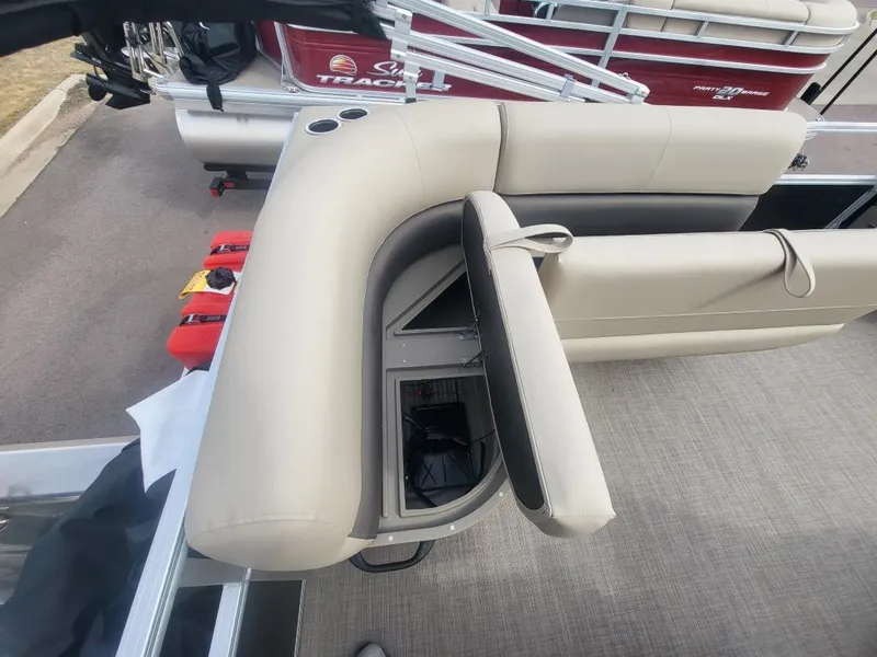 Slide: The Image of 2025 Sun Tracker Party Barge 16 DLX with open storage compartment and beige seating. - 12