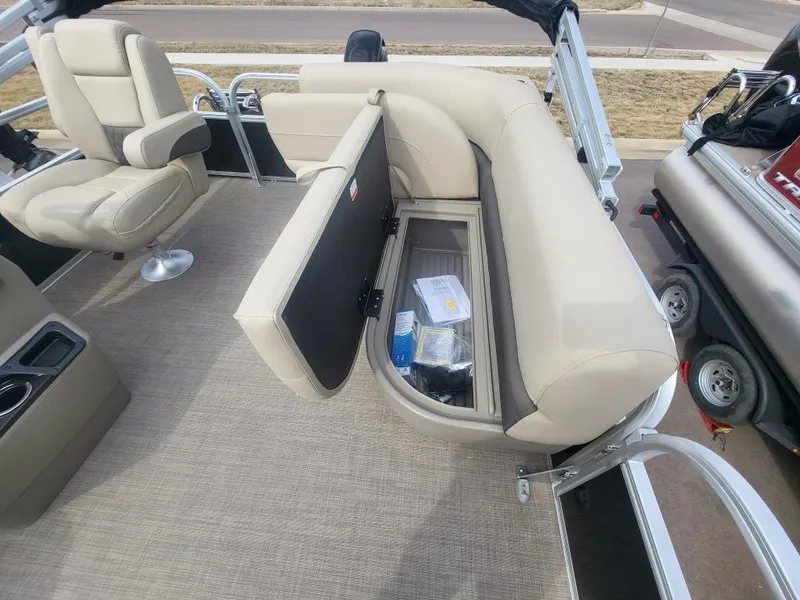 Slide: The Image of 2025 Sun Tracker Party Barge 16 DLX interior with open storage compartment and seating. - 13