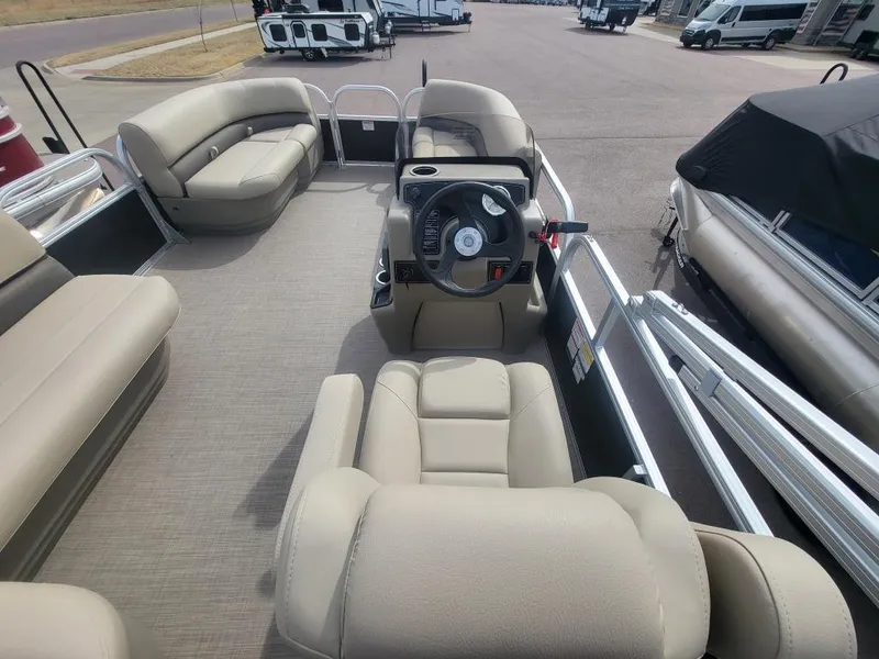 Slide: The Image of 2025 Sun Tracker Party Barge 16 DLX interior with beige seating and steering console. - 15