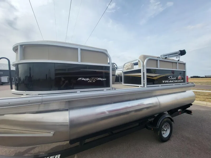 Slide: The Image of 2025 Sun Tracker Party Barge 16 DLX pontoon boat on trailer, side view. - 2