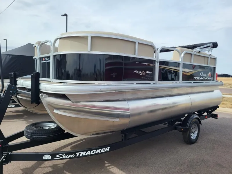 Slide: The Image of 2025 Sun Tracker Party Barge 16 DLX pontoon boat on trailer, outdoor display. - 3