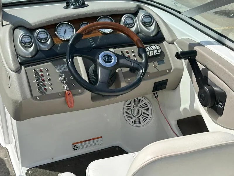 Slide: The Image of 2006 Cobalt 250 boat dashboard with steering wheel, gauges, and control panel. - 13