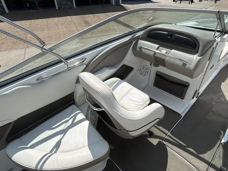 Slide: The Image of Interior of a 2006 Cobalt 250 boat, featuring white leather seating and sleek dashboard design. - 5