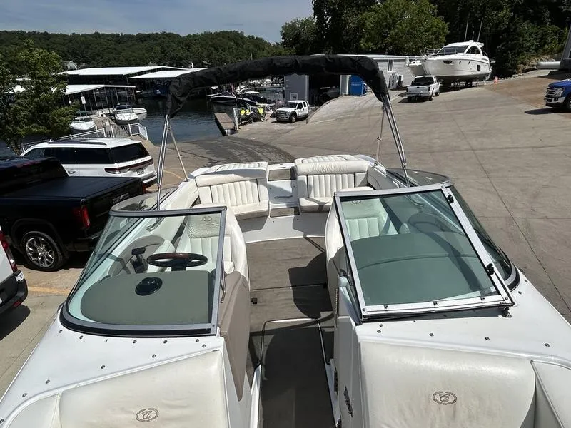 Slide: The Image of 2006 Cobalt 250 boat docked at marina with surrounding vehicles and watercraft. - 8