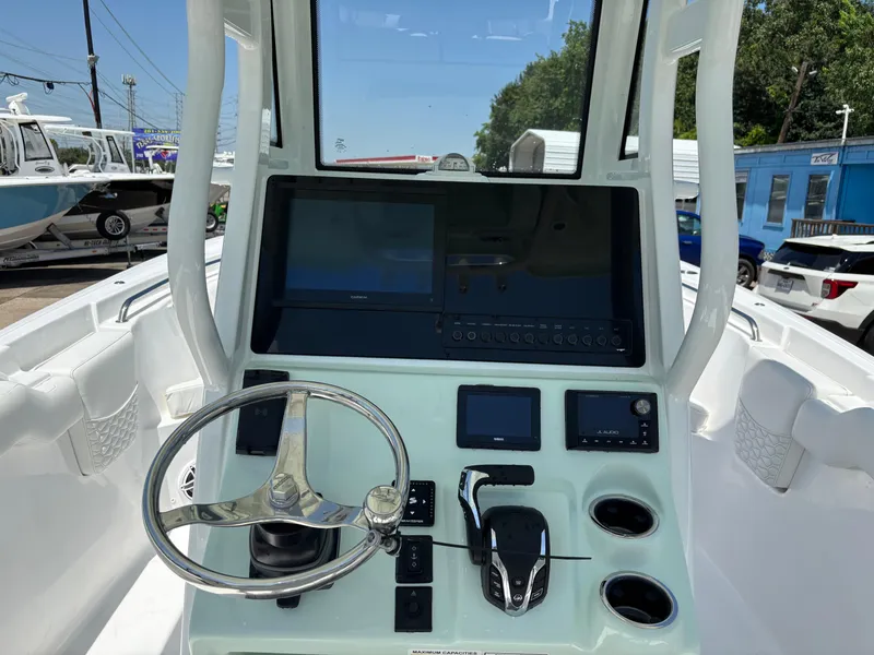 Slide: The Image of 2026 Tidewater 232 LXF boat dashboard with steering wheel, controls, and navigation screens. - 5