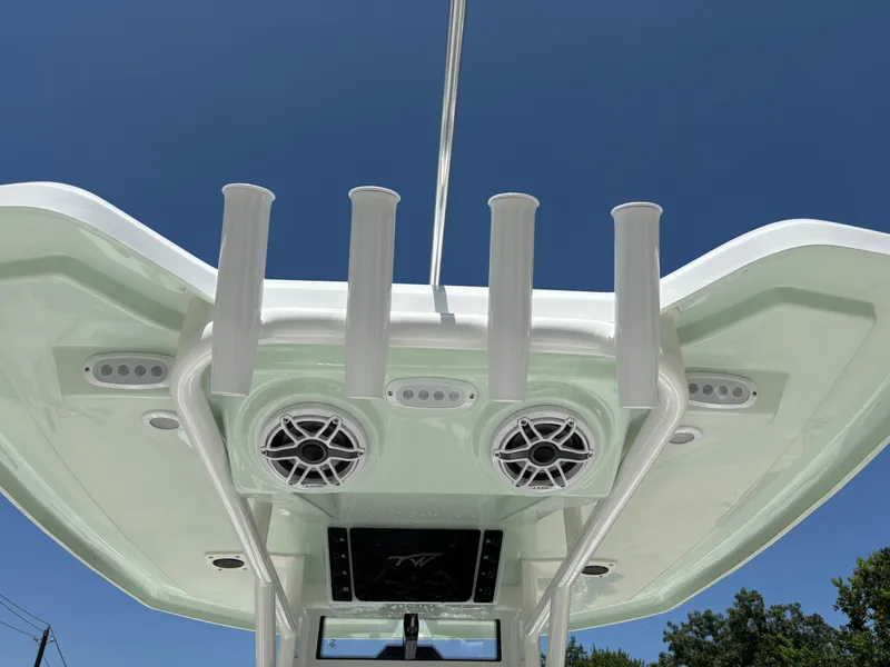 Slide: The Image of 2026 Tidewater 232 LXF boat roof with rod holders and speakers against blue sky. - 6