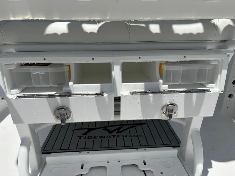 Slide: The Image of 2026 Tidewater 232 LXF boat storage compartments with secure locks and branded mat. - 8