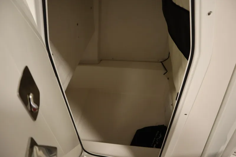 Slide: The Image of 2026 Sea Fox 228 Commander interior storage compartment, open door view. - 23