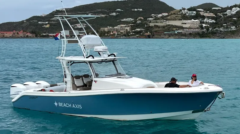 Slide: The Image of 2017 Edgewater 368CC boat on turquoise water near coastal hills. - 3