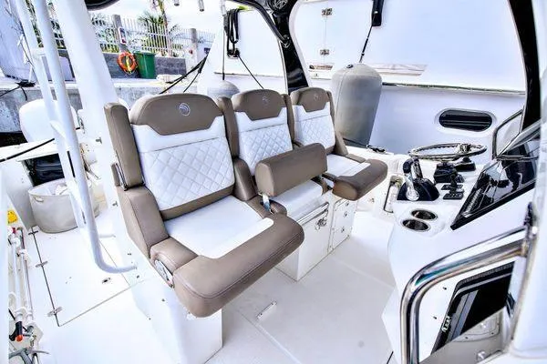 Slide: The Image of 2017 Edgewater 368CC boat interior with three cushioned seats and control panel. - 5