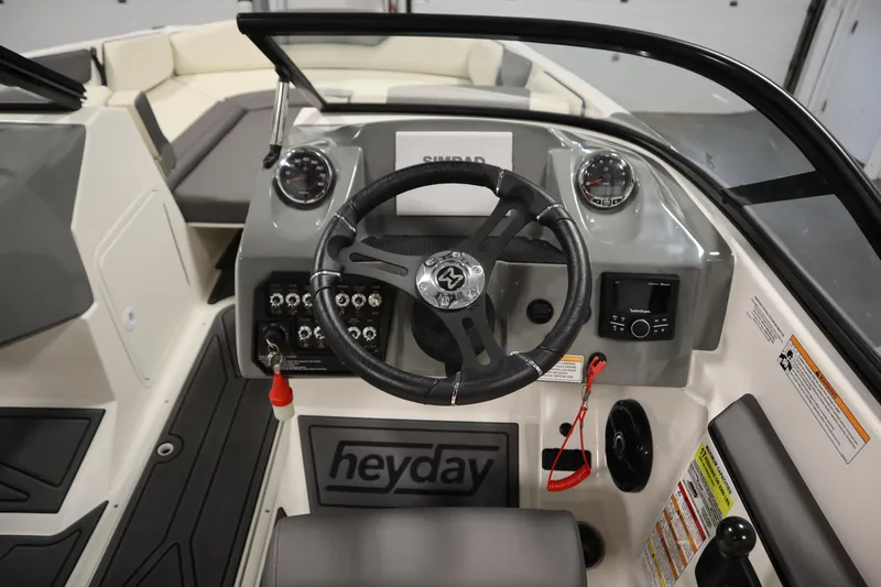 Slide: The Image of 2025 Heyday WT Surf boat dashboard with steering wheel and control panel. - 14