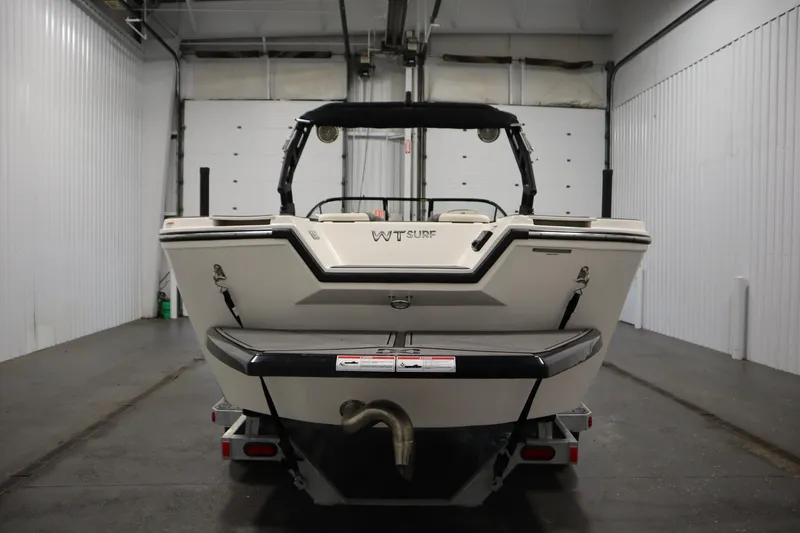 Slide: The Image of 2025 Heyday WT Surf boat in a garage, rear view. - 5