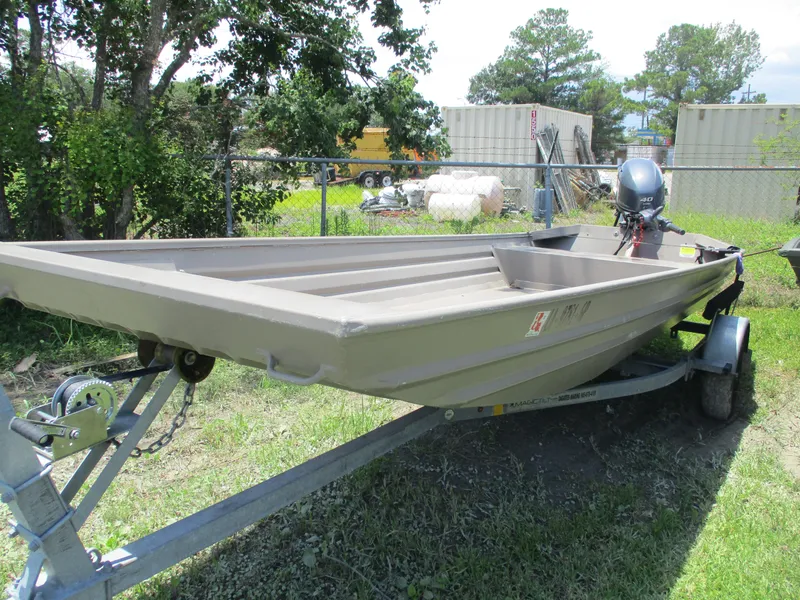 Slide: The Image of 2023 Alweld 1648SS boat on trailer, parked outdoors near trees and storage containers. - 2