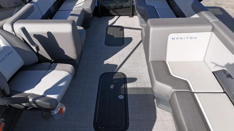 Slide: The Image of 2025 Manitou Cruise boat interior with gray seating and spacious layout. - 10