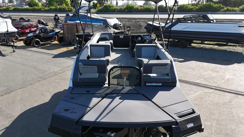 Slide: The Image of 2025 Manitou Cruise boat with modern seating and sleek design, parked outdoors. - 20