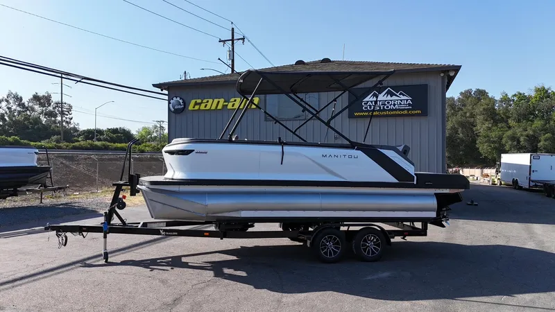 Slide: The Image of 2025 Manitou Cruise pontoon boat on trailer at California Custom dealership. - 4