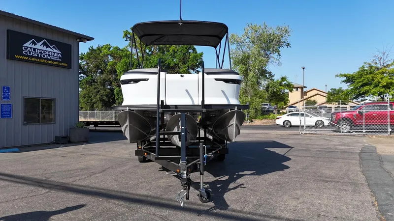 Slide: The Image of 2025 Manitou Cruise boat on trailer at California Custom dealership. - 6