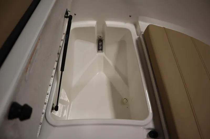 Slide: The Image of 2026 Bayliner 20 Cc Trophy storage compartment with beige seating. - 13
