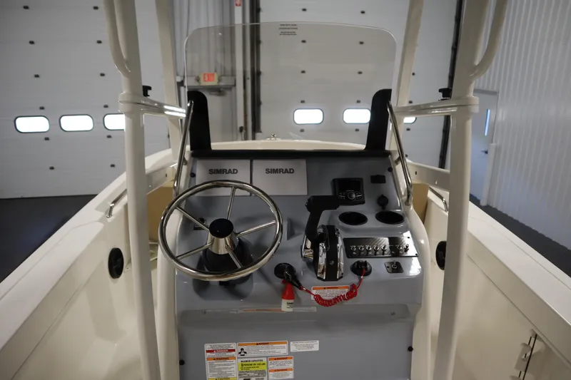 Slide: The Image of 2026 Bayliner 20 Cc Trophy boat console with steering wheel and controls in a garage. - 21