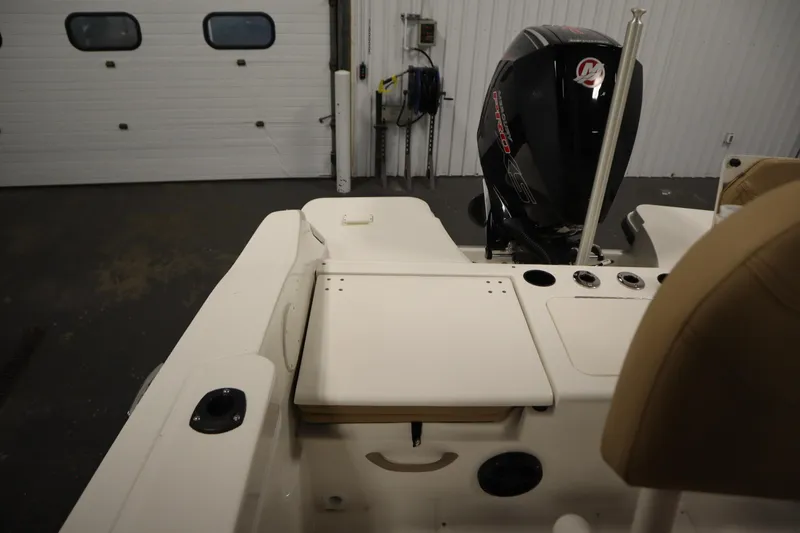 Slide: The Image of 2026 Bayliner 20 Cc Trophy boat interior with motor, in a garage setting. - 30