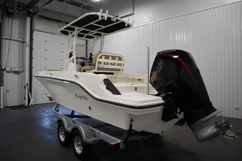 Slide: The Image of 2026 Bayliner 20 Cc Trophy boat with powerful outboard motor in a showroom. - 6