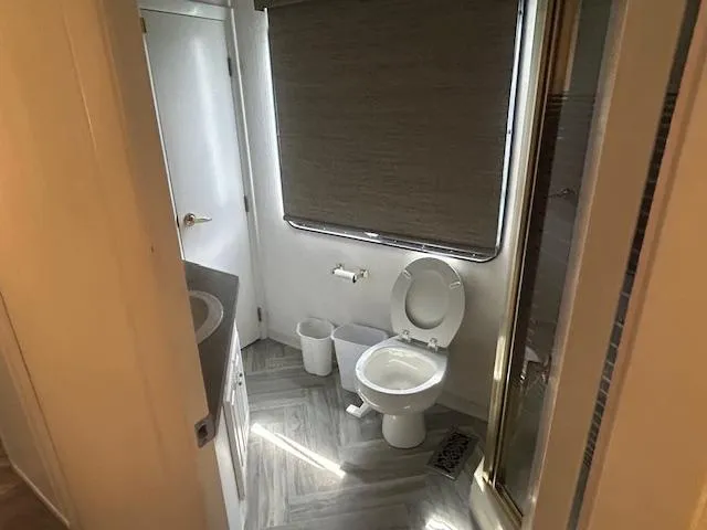 Slide: The Image of Bathroom interior of a 1999 Skipperliner 59 x 14 houseboat, featuring toilet and shower. - 12