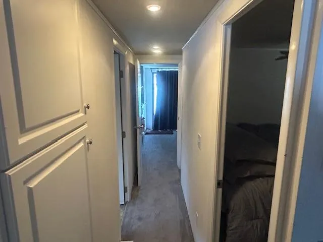 Slide: The Image of Hallway inside 1999 Skipperliner 59 x 14 houseboat, featuring white walls and carpeted floor. - 13