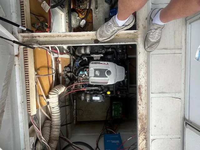 Slide: The Image of Engine compartment of a 1999 Skipperliner 59 x 14 houseboat, showing mechanical components and wiring. - 20