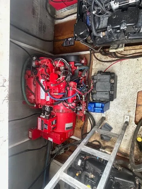 Slide: The Image of Engine compartment of a 1999 Skipperliner 59 x 14 Houseboat, featuring a red generator. - 21