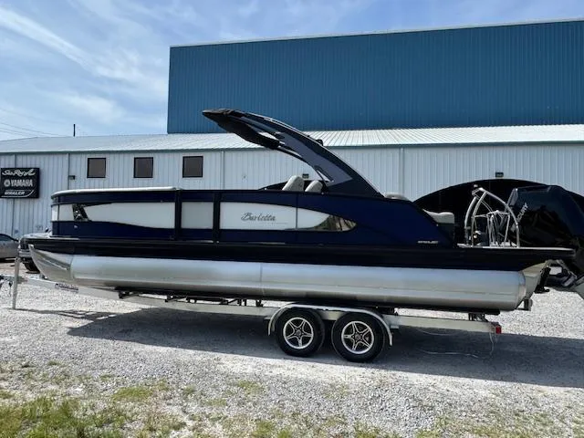 Slide: The Image of 2026 Barletta LUSSO 25 UCA pontoon boat on trailer, parked outdoors. - 7