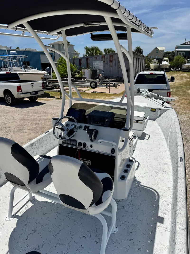Slide: The Image of 2015 Haynie 25 Magnum boat with dual seats and steering console, parked outdoors. - 2